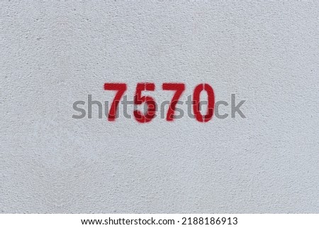 Red Number 7570 on the white wall. Spray paint.
