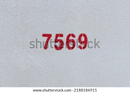 Red Number 7569 on the white wall. Spray paint.
