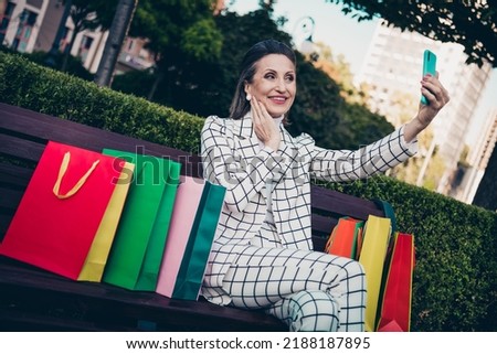 Photo of positive dreamy woman wear plaid jacket recording self video modern device shoppers outside city residential complex
