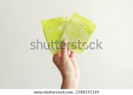 close-up of menstruation pads in hand on gray background