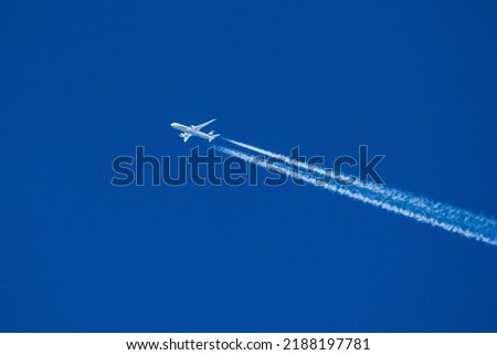 Sharp telephoto close-up of jet plane aircraft with contrails cruising from Tokyo to Chicago, altitude AGL 39,000 feet, ground speed 556 knots. Royalty-Free Stock Photo #2188197781