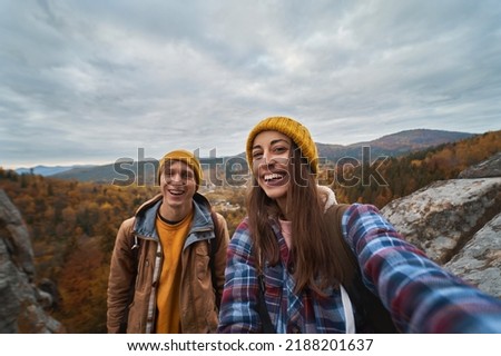 Happy tourist couple making selfie with nature view during travel together, enjoying active lifestyle vacations outdoors