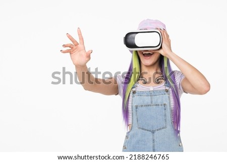 Cheerful young teenager girl woman hipster using VR glasses playing video games online, using modern gadgets touching copy space isolated in white background