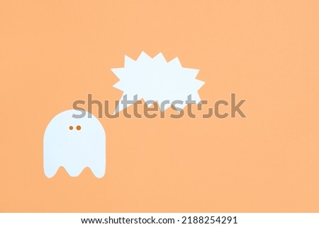 Trendy halloween design, white cute ghost with a shouting blank speech bubble on pastel orange color background, minimal composition with copy space.