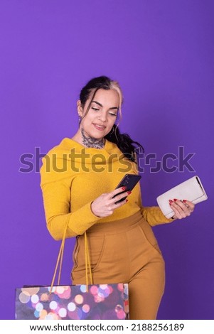 A women holding her wallet and shopping bag while showing a credit card.  Shopping concept. Studio shot.