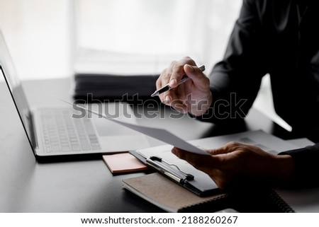 Business men are looking at the company's financial documents to analyze problems and find solutions before bringing the information to a meeting with a partner. Financial concept. Royalty-Free Stock Photo #2188260267