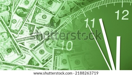Clock and assorted American coins banknotes. Time is money idea