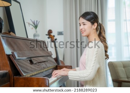 Asian women pianist is enjoying playing piano in the studio.