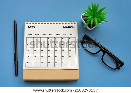 March 2023 desk calendar on blue background. Directly above. Flat lay. Copy space.