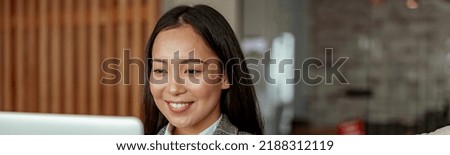 Close up of smiling asian business woman working laptop sitting in cozy office. High quality photo