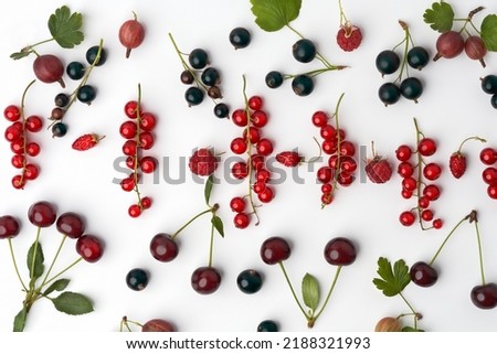 Berry pattern of red and black currants, gooseberries, strawberries and raspberries on a white background. View from above. Macro photography.                               