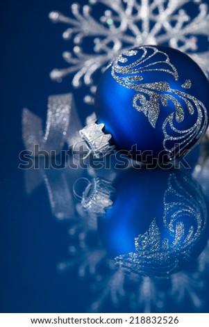 Blue and silver christmas ornaments on dark blue xmas background with space for text