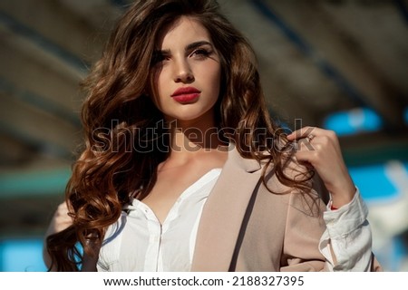 Fashion woman in trendy autumn outfit posing outdoor near see. Vogue style model girl in casual jacket and jeans outdoors. Brunette lady lifestyle portrait. Royalty-Free Stock Photo #2188327395