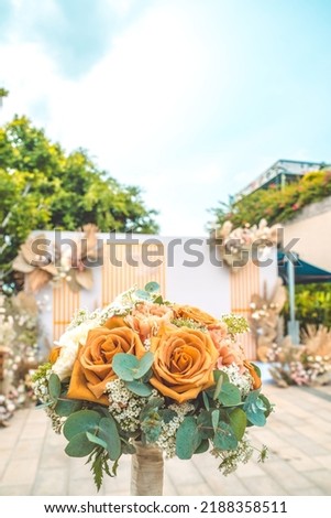 Decorating the arch with flowers and fabric for a wedding ceremony in nature. Wedding Ceremony with flowers outside in the garden with hanging lights.