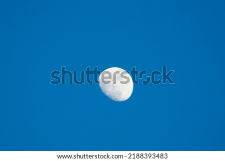 lonly silver crescent moon in a blue sky