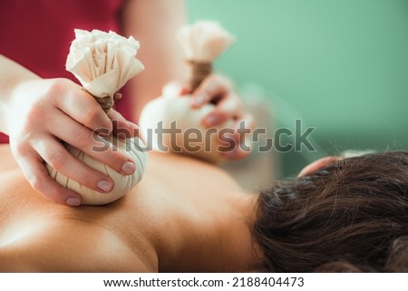 Kizhi massage or herbal bolus bags Ayurveda massage, hands of an Ayurveda Massage therapist pressing herbal bolus bags onto client’s skin Royalty-Free Stock Photo #2188404473