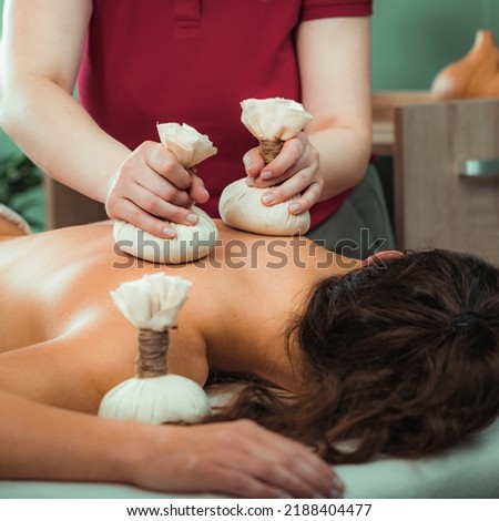 Kizhi massage or herbal bolus bags Ayurveda massage, hands of an Ayurveda Massage therapist pressing herbal bolus bags onto client’s skin Royalty-Free Stock Photo #2188404477