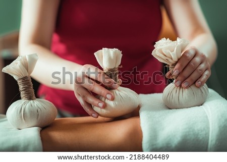 Kizhi massage or herbal bolus bags Ayurveda massage, hands of an Ayurveda Massage therapist pressing herbal bolus bags onto client’s skin Royalty-Free Stock Photo #2188404489