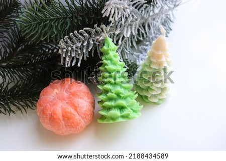 New Year's decorative handmade candles made of natural soy wax in the form of a Christmas tree and a tangerine