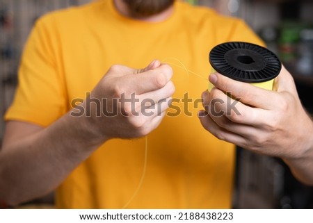 Close-up of a man choosing a fishing line in a fishing store, accessories for a fisherman Royalty-Free Stock Photo #2188438223
