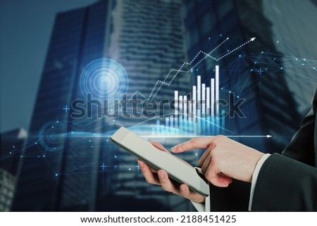 Close up of businessman hand pointing at cellphone with abstract glowing polygonal business graph hologram with growing arrow on blurry city background. Financial growth, market and trade concept