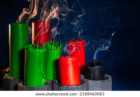 Happy kwanzaa concept with black, red and green candles on dark background, selective focus