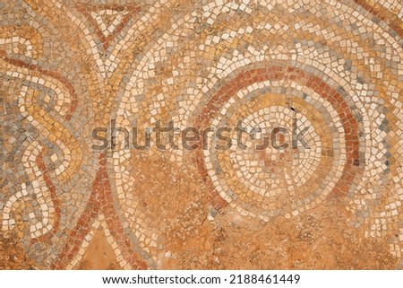 A fragment of a beautiful ancient mosaic of an ancient Roman structure, the archaeological site of Sbeitla, Tunisia. Royalty-Free Stock Photo #2188461449