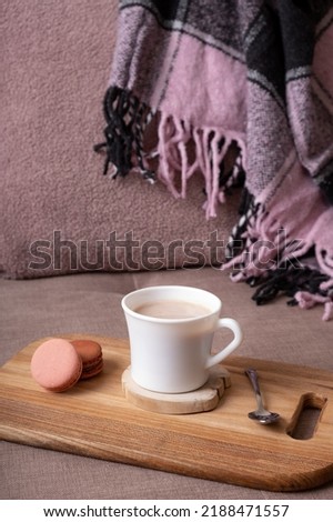 Autumn mood background with cup of cocoa, plaid on sofa. Hot drink in autumn concept.