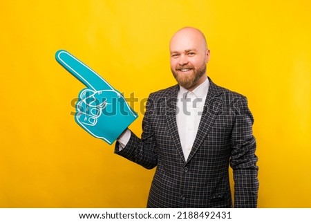 A picture of a business man holding a fan glove and smiling at the camera