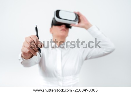 Woman Wearing Vr Glasses And Pointing On Recent Updates With Pen. Businesswoman Having Virtual Reality Eyeglasses And Presenting New Idea. Executive Showing Late Data.