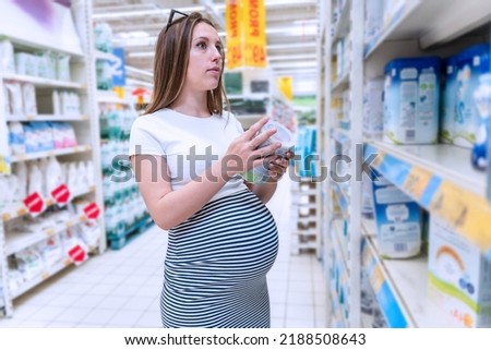 Infant formula woman shopping. Young pregnant woman buying infant baby formula milk on supermarket background. Healthy baby formula concept Royalty-Free Stock Photo #2188508643