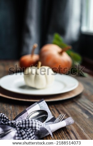 Silverware on Thanksgiving Day holiday table buffalo check napkin tied with black and white bow. Selective focus on for and spoon with blurred foreground and background. 