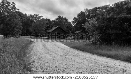 Black and white picture of old barns on a country dirt road