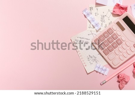 On a pink background, a scribbler, a calculator, a pencil, school supplies with a place for an inscription. High quality photo Royalty-Free Stock Photo #2188529151