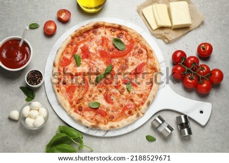 Delicious pizza Margherita and ingredients on light grey table, flat lay