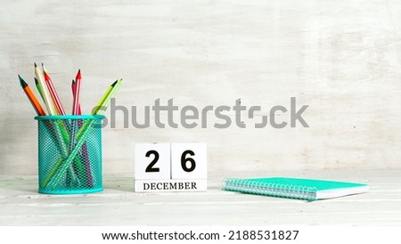 December 26 calendar. The concept of the date of the season. Pencils in a basket against the background of a notebook and the date of the month. Copy space calendar cube