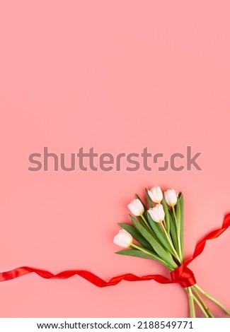 White tulips flowers, flatlay. Beautiful bouquet of tulips on stem with leaves isolated on pastel pink background. Naturе object for design to women's day, mother's day, anniversary. Spring concept
