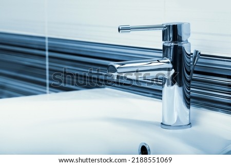 Clean white sink with shiny water tap in bathroom