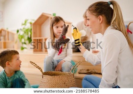 Teacher and preschool children playing with finger puppets Royalty-Free Stock Photo #2188578485