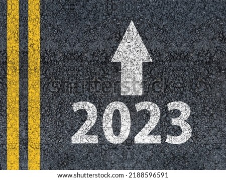 happy new year 2023 Year 2023 and an arrow written on an asphalt road 
