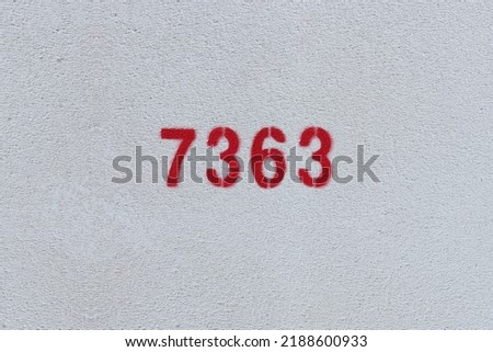 Red Number 7363 on the white wall. Spray paint.
