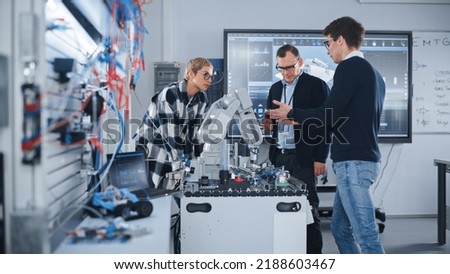 Male Teacher Attentively Listening Opinion of His Smart Students During Lesson at University. People Discussing Robotic Prototype of Hand. Computer Science Education Concept Royalty-Free Stock Photo #2188603467