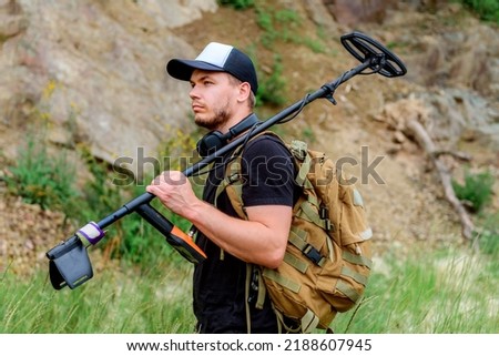 Search for treasure and ancient values. Archeology. Man with a metal detector.