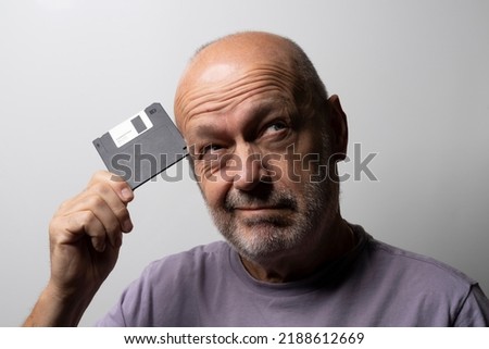 a man with an old floppy disk in his hand