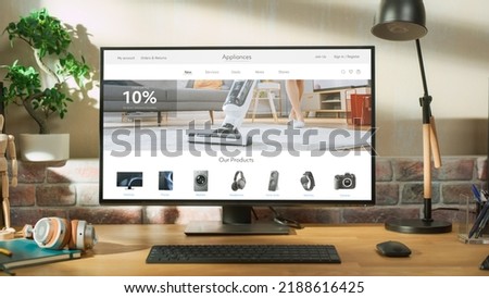 At Home Office: Desktop Computer Standing on Adjustable Table With Page of Online Store of Electronics. e-Commerce Concept of Purchasing, Buying, Ordering Tech Devices on Website Royalty-Free Stock Photo #2188616425