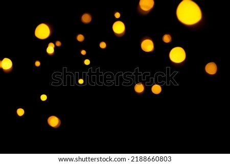 Gold bokeh on dark background. Defocused golden lights. New Year, Christmas background, abstract texture