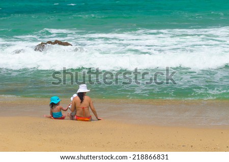 A mother and her daughters are playing on the beach at Phuket, Thailand
