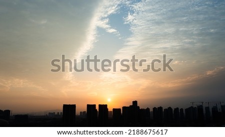 City buildings under sunset sky.
