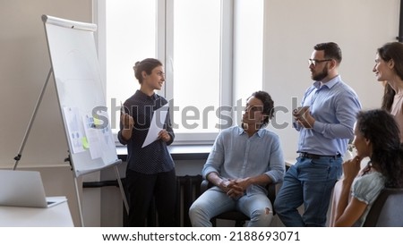 Corporate training, seminar event led by attractive skilled Indian female business trainer, discuss deal, forecasting concept. Diverse clients and company representative met in office with flip Royalty-Free Stock Photo #2188693071