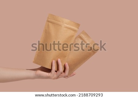 Woman's hands hold cardboard packages for tea or snacks on a beige background. Tea branding and packaging mockup. High quality photo Royalty-Free Stock Photo #2188709293